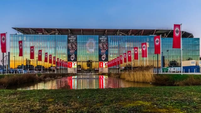 Het Bosuilstadion bij schemering, gezien vanaf de vijverzijde
